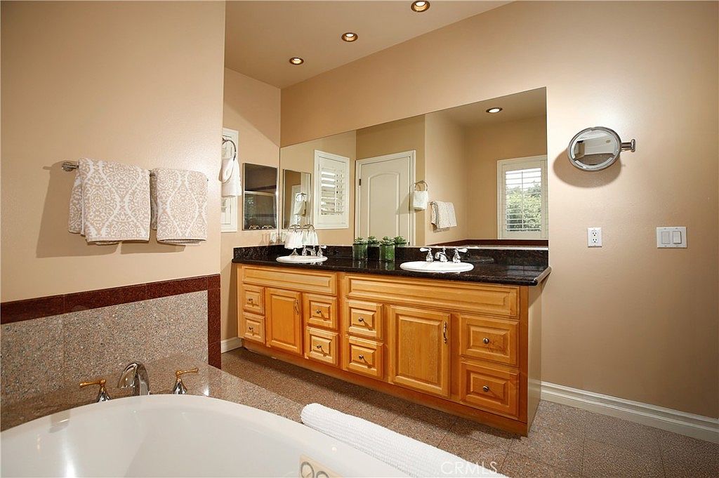 The spa-inspired primary bath with double vanity, soaking tub, and granite surfaces